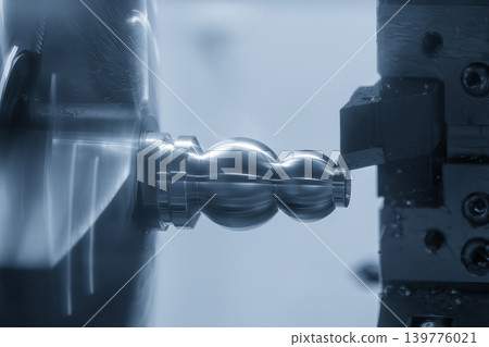 High-precision surface finishing process of a metal shaft part on a CNC lathe machine in a blue-toned scene. High-precision surface finishing process of a metal shaft part on a CNC lathe machine in a blue-toned scene. 139776021