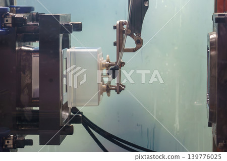 Automated robotic gripper performing material handling by extracting plastic injection parts from a molding machine. Automated robotic gripper performing material handling by extracting plastic injection parts from a molding machine. 139776025
