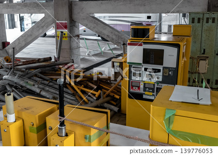 A disused parking ticket payment machine is located in a multi-story parking garage. 139776053