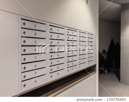 Modern White Numbered Mailboxes in Apartment Building Hallway Modern White Numbered Mailboxes in Apartment Building Hallway 139776405