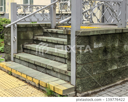Stone entrance steps with wrought iron railing and tactile paving 139776422