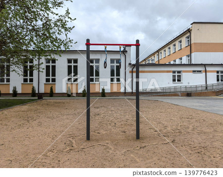 Outdoor gymnastics rings and pull up bar at school sports ground Outdoor gymnastics rings and pull up bar at school sports ground 139776423