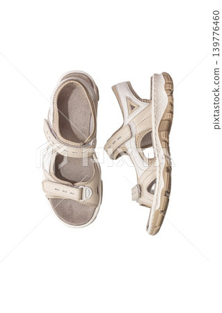A pair of casual beige and white sandals with adjustable straps and cushioned sole, isolated on a white background. 139776460