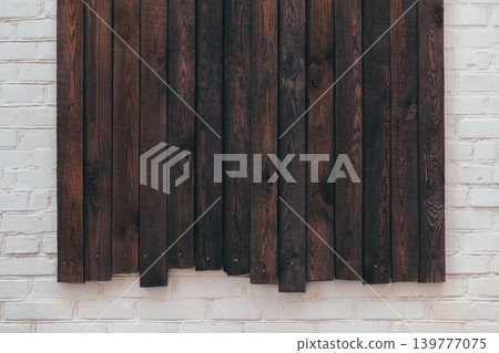 Dark rustic wooden boards on white brick wall. Wooden background. Dark rustic wooden boards on white brick wall. Wooden background. 139777075
