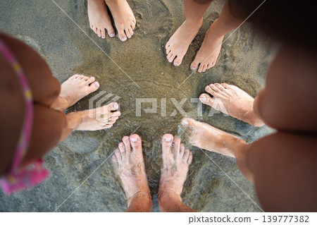 Family feet standing in circle on Greece beach Family feet standing in circle on Greece beach 139777382