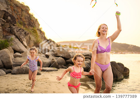 Mother and daughters enjoying summer vacation by the sea 139777389