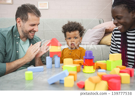 Multiracial family enjoys building with colorful blocks at home Multiracial family enjoys building with colorful blocks at home 139777538