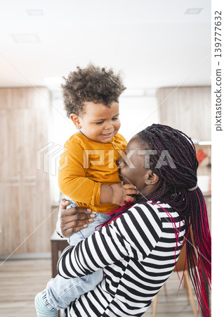 Multiracial family enjoying playful moments indoors with toddler Multiracial family enjoying playful moments indoors with toddler 139777632