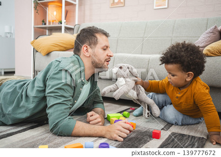 Multiracial family having fun in a cozy living room Multiracial family having fun in a cozy living room 139777672