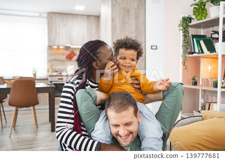 Multiracial family enjoying playful afternoon in modern living room Multiracial family enjoying playful afternoon in modern living room 139777681