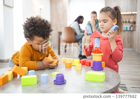 Multiracial children building blocks at home during daytime play Multiracial children building blocks at home during daytime play 139777682