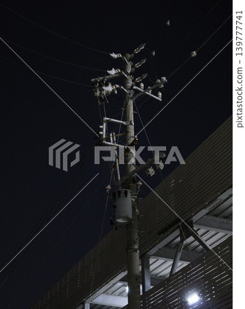 A minimalist background featuring simple utility poles and the sky. 139777741