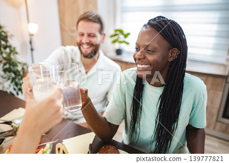 Celebrating friendship with cheers at a cozy dining table Celebrating friendship with cheers at a cozy dining table 139777821