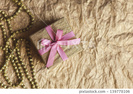 Golden gift box with pink bow on the gold background. Holiday concept. Golden gift box with pink bow on the gold background. Holiday concept. 139778106