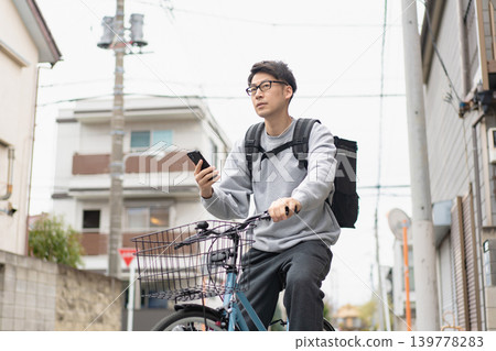 Man delivering by bicycle Man delivering by bicycle 139778283
