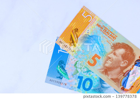 Five, ten dollar notes from New Zealand are placed on clean white surface Five, ten dollar notes from New Zealand are placed on clean white surface 139778378