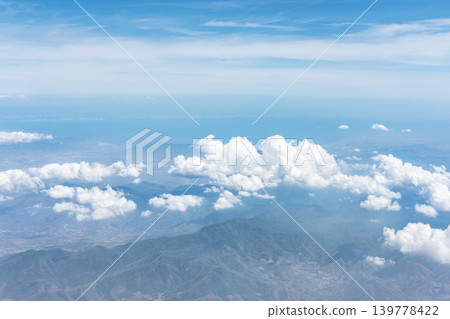 Beautiful clouds over the natural landscape, view through airplane window Beautiful clouds over the natural landscape, view through airplane window 139778422