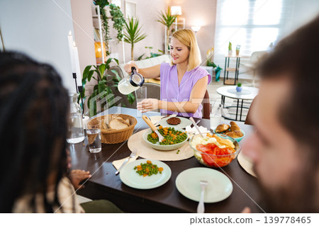 Enjoying a vibrant home-cooked meal with friends at noon Enjoying a vibrant home-cooked meal with friends at noon 139778465
