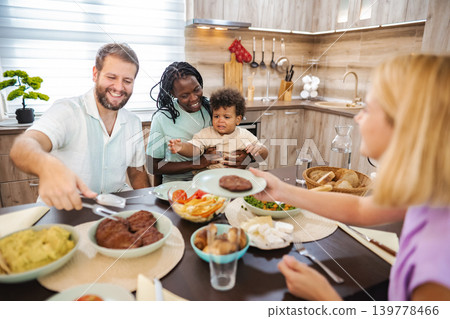 Family gathers at the kitchen table for dinner Family gathers at the kitchen table for dinner 139778466