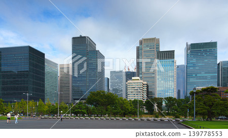 Tokyo, Japan - Oct 01 2024, A panoramic view of the Chiyoda district's skyscrapers on background of cloudy sky, with a parking lot in the foreground, at daytime, Tokyo, Japan Tokyo, Japan - Oct 01 2024, A panoramic view of the Chiyoda district's skyscrapers on background of cloudy sky, with a parking lot in the foreground, at daytime, Tokyo, Japan 139778553