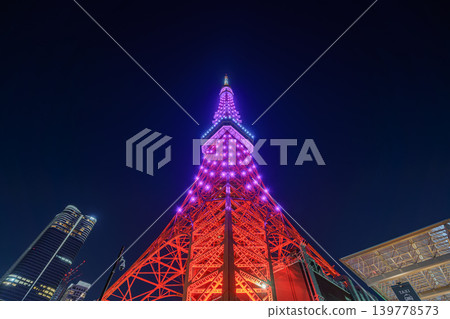 Tokyo, Japan - Oct 1 2024, panoramic view from below of the Tokyo Tower, illuminated by red light at night, with purple neon lights at the top, and a dark, clear sky, without people, Tokyo, Japan Tokyo, Japan - Oct 1 2024, panoramic view from below of the Tokyo Tower, illuminated by red light at night, with purple neon lights at the top, and a dark, clear sky, without people, Tokyo, Japan 139778573