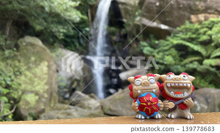 Okinawan scenery and smiling Shisa, sanshin (Okinawan stringed instrument), flower hat, copy space, Todoroki Falls 139778683