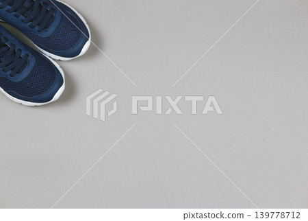 Classic blue sneakers on the grey background. Concept for healthy lifestyle and everyday training. Classic blue sneakers on the grey background. Concept for healthy lifestyle and everyday training. 139778712