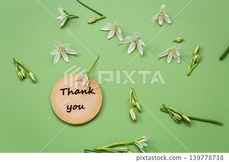 Delicate white flowers and wooden thank you sign on green surface Delicate white flowers and wooden thank you sign on green surface 139778738