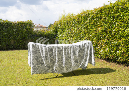a sheet hung out to dry in the garden a sheet hung out to dry in the garden 139779016