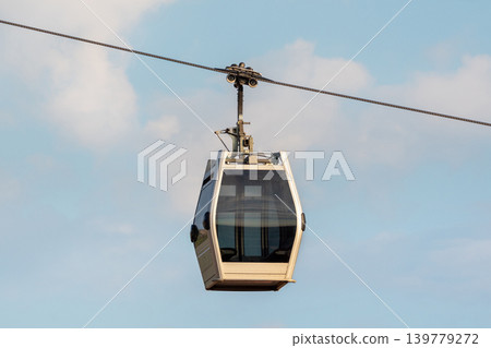 Cable car glides through open sky. Close up. Cable car glides through open sky. Close up. 139779272