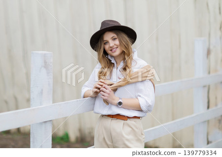 Young woman posing in cowboy hat outdoors 139779334