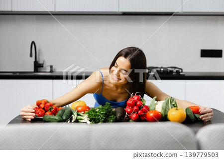 Smiling woman embracing fresh fruits and vegetables 139779503