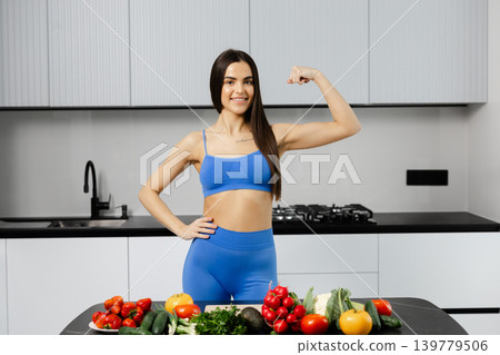 Woman showing biceps promoting healthy diet and fitness Woman showing biceps promoting healthy diet and fitness 139779506