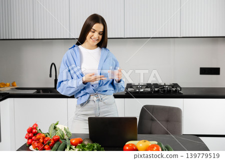Young woman learning healthy cooking online in kitchen 139779519