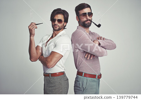 Fashion, men and sunglasses or pipe in studio with vintage model, hipster outfit and confidence with arms crossed. Friends, people and attitude with 70s style or retro clothes with white background Fashion, men and sunglasses or pipe in studio with vintage model, hipster outfit and confidence with arms crossed. Friends, people and attitude with 70s style or retro clothes with white background 139779744