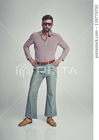 Vintage, fashion and portrait of man with 70s retro aesthetic in gray background of studio. Smoking, pipe and person with confidence and pride in funky sunglasses, clothes and unique style from past Vintage, fashion and portrait of man with 70s retro aesthetic in gray background of studio. Smoking, pipe and person with confidence and pride in funky sunglasses, clothes and unique style from past 139779792