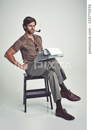 Fashion, man and typewriter or pipe in studio with vintage model, hipster outfit and confidence on chair. Relax, person and reading with 70s style, calm expression and smoking with white background 139779856