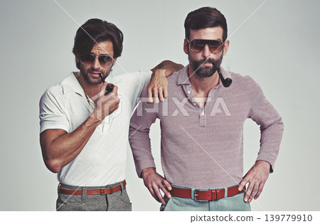 Fashion, men and sunglasses or pipe with vintage model, hipster outfit or confidence with calm expression in studio. Friends, people and attitude with 70s style or retro clothes with white background 139779910