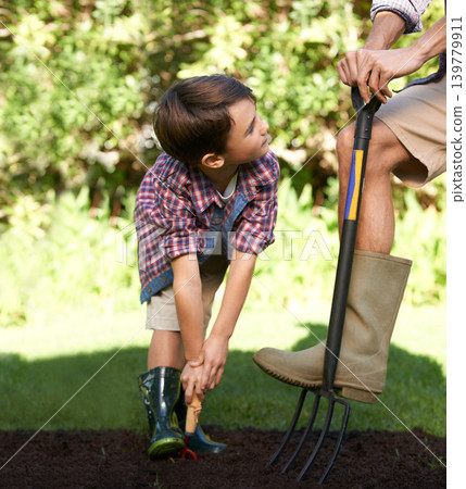 Child, father and help with gardening in nature using tools for agriculture conservation and ecology education. Soil, compost and a man teaching boy kid to plant with fork for organic earth support 139779911
