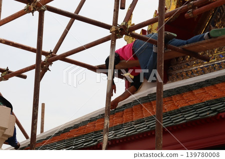 Workers on Scaffolding Repairing Traditional Roof Workers on Scaffolding Repairing Traditional Roof 139780008