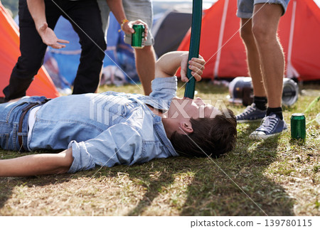 Alcohol, drinking and funnel with man at festival, on ground for event, party or social gathering. Beer, grass and young drunk person with friends on grass or field outdoor at camp for celebration 139780115
