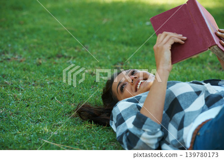 Happy woman, student and lying with book on green grass for literature, studying or story in nature. Female person, bookworm or young adult with smile and notebook for reading or education at park Happy woman, student and lying with book on green grass for literature, studying or story in nature. Female person, bookworm or young adult with smile and notebook for reading or education at park 139780173