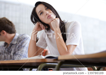 University, thinking and woman in classroom with books for development in learning, opportunity and future. Education, knowledge and growth for college student in lecture, studying for exam or test. University, thinking and woman in classroom with books for development in learning, opportunity and future. Education, knowledge and growth for college student in lecture, studying for exam or test. 139780189