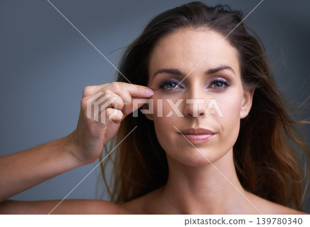 Makeup, portrait and woman with cheek pinch in studio for facelift, cosmetics or anti aging results on grey background. Beauty, face and female model with collagen, fine lines or contour hack 139780340