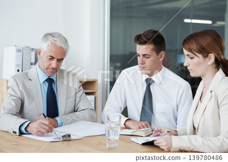 Business people, writing and planning on paperwork for collaboration, strategy or notes at office. Group, teamwork or employees with documents or paperwork in meeting for brainstorming at workplace 139780486