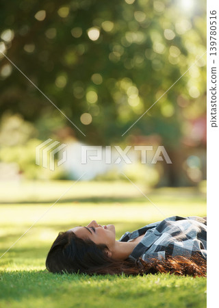 Happy, park and woman on grass to relax for rest in garden, nature or field with smile or peace. Smile, freedom and female person on break with smile on face for summer vacation, holiday or wellness Happy, park and woman on grass to relax for rest in garden, nature or field with smile or peace. Smile, freedom and female person on break with smile on face for summer vacation, holiday or wellness 139780516
