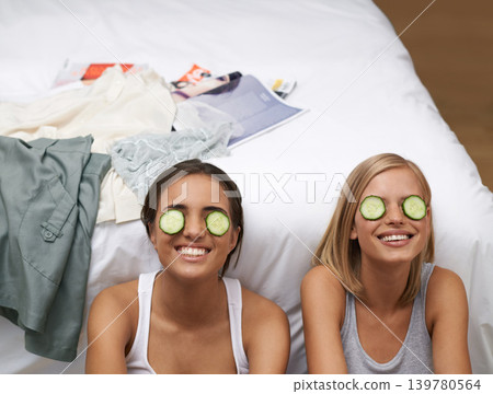 Women, spa and friends in bedroom, smile and self care on bed together. Sisters, cucumber and wellness connect for home, relaxation and beauty talk for happiness, skincare and antioxidant treatment Women, spa and friends in bedroom, smile and self care on bed together. Sisters, cucumber and wellness connect for home, relaxation and beauty talk for happiness, skincare and antioxidant treatment 139780564