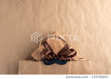 Fathers Day gift presenting in craft paper bag Fathers Day gift presenting in craft paper bag 139780841