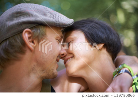 Couple, closeup and embrace outdoors for date with wristband for festival, concert or adventure together. Man, woman and smile with flat cap for summer in nature, forest or woods with happiness 139780866