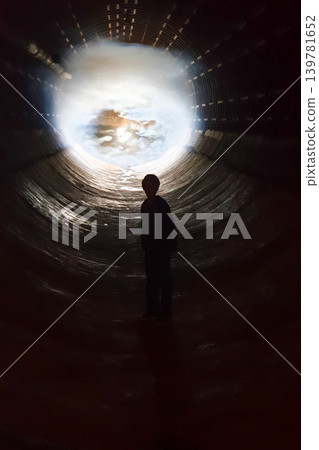 Silhouette Standing Inside Tunnel Facing Bright Sky Opening Silhouette Standing Inside Tunnel Facing Bright Sky Opening 139781652